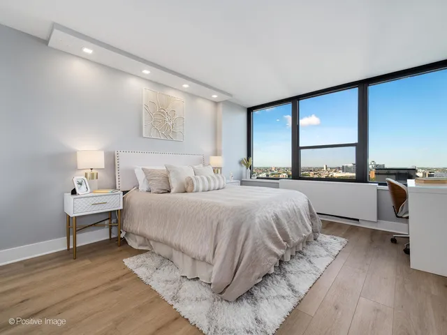 a bedroom with a bed and a large window