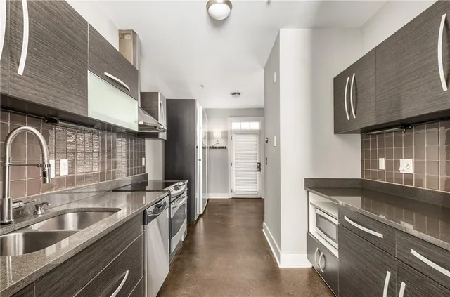 a kitchen with stainless steel appliances granite countertop a sink and a stove
