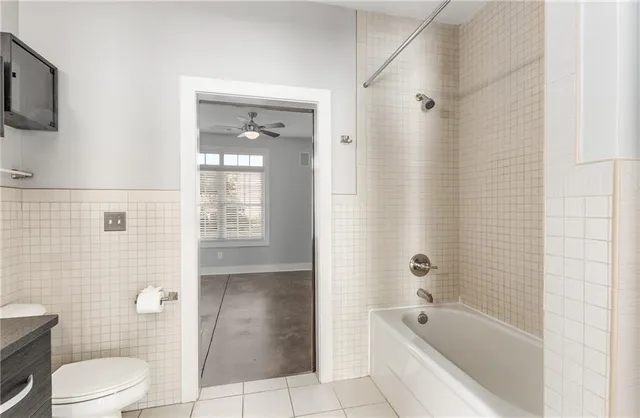 a bathroom with a bathtub shower sink mirror and toilet