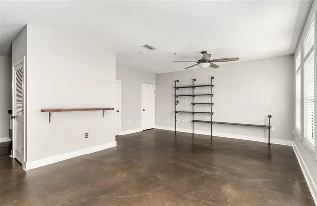 an empty room with windows and cabinet