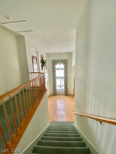 141 Rancho Maria Street Las Vegas, NV 89148 - Photo 8 of 30 A carpeted staircase leads down to a bright living space with polished wood flooring.