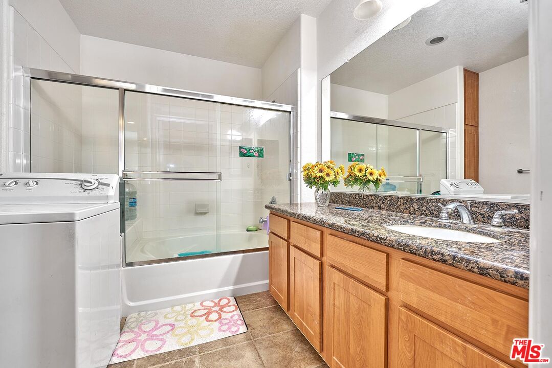 12664 Chapman Avenue, Unit 1208 Garden Grove, CA 92840 - Photo 18 of 29 a bathroom with a granite countertop sink and a mirror