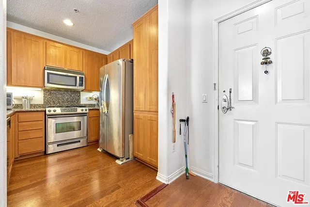 a kitchen with stainless steel appliances a refrigerator and a stove top oven