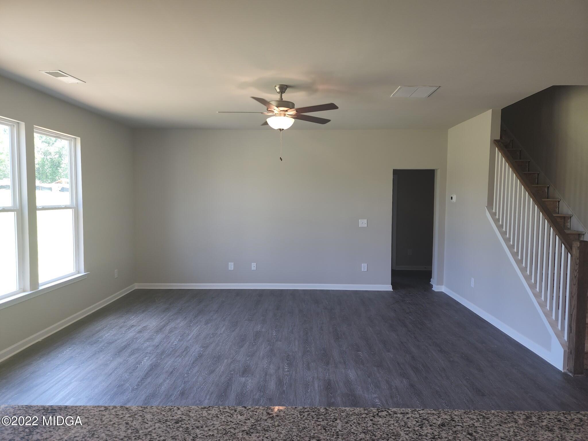 266 Presidents Way Forsyth, GA 31029 - Photo 5 of 21 an empty room with wooden floor fan and windows