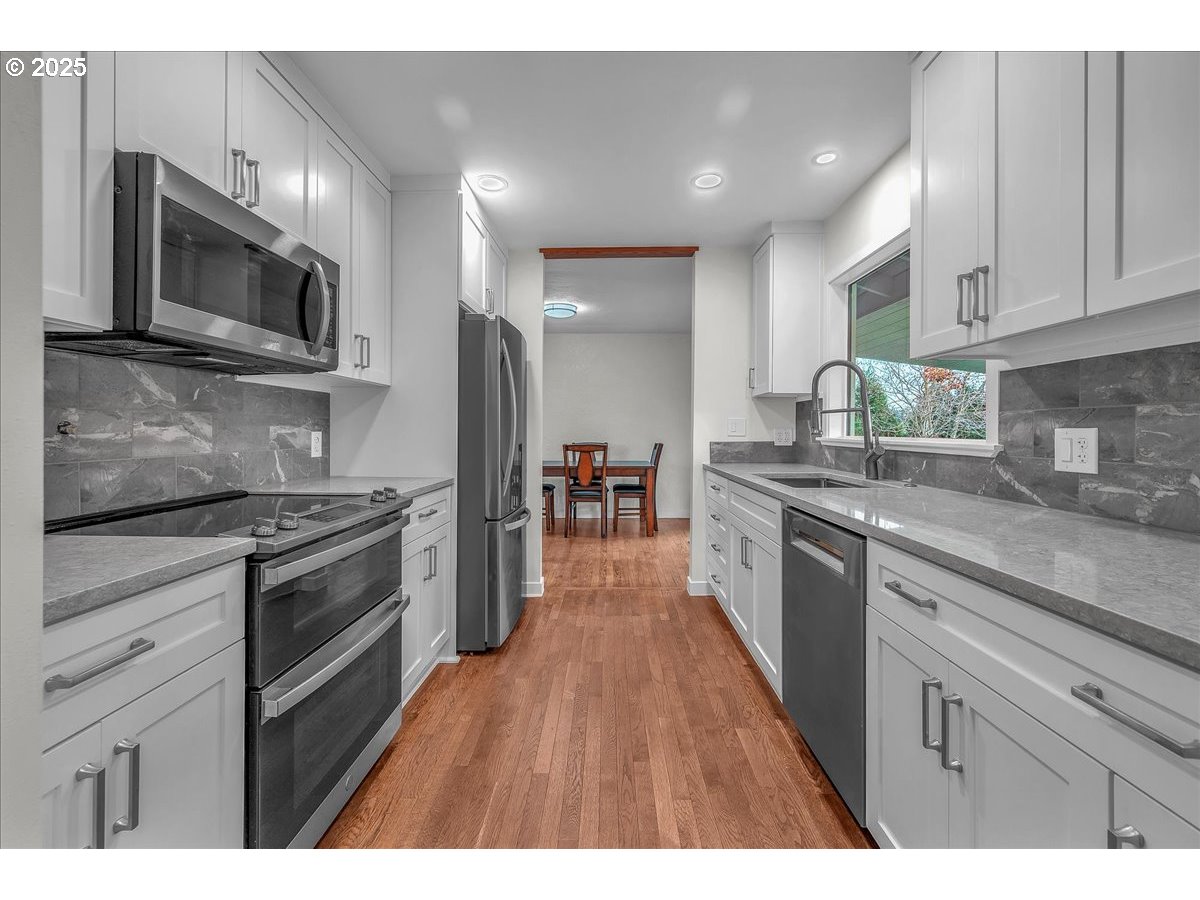 19448 Southwest Scholls Ferry Road Beaverton, OR 97007 - Photo 12 of 45 a large kitchen with cabinets wooden floor and stainless steel appliances
