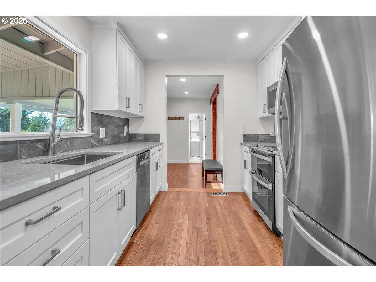 19448 Southwest Scholls Ferry Road Beaverton, OR 97007 - Photo 13 of 45 a kitchen with stainless steel appliances granite countertop a refrigerator and a sink
