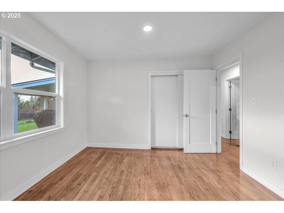 19448 Southwest Scholls Ferry Road Beaverton, OR 97007 - Photo 23 of 45 a view of an empty room with wooden floor and a window