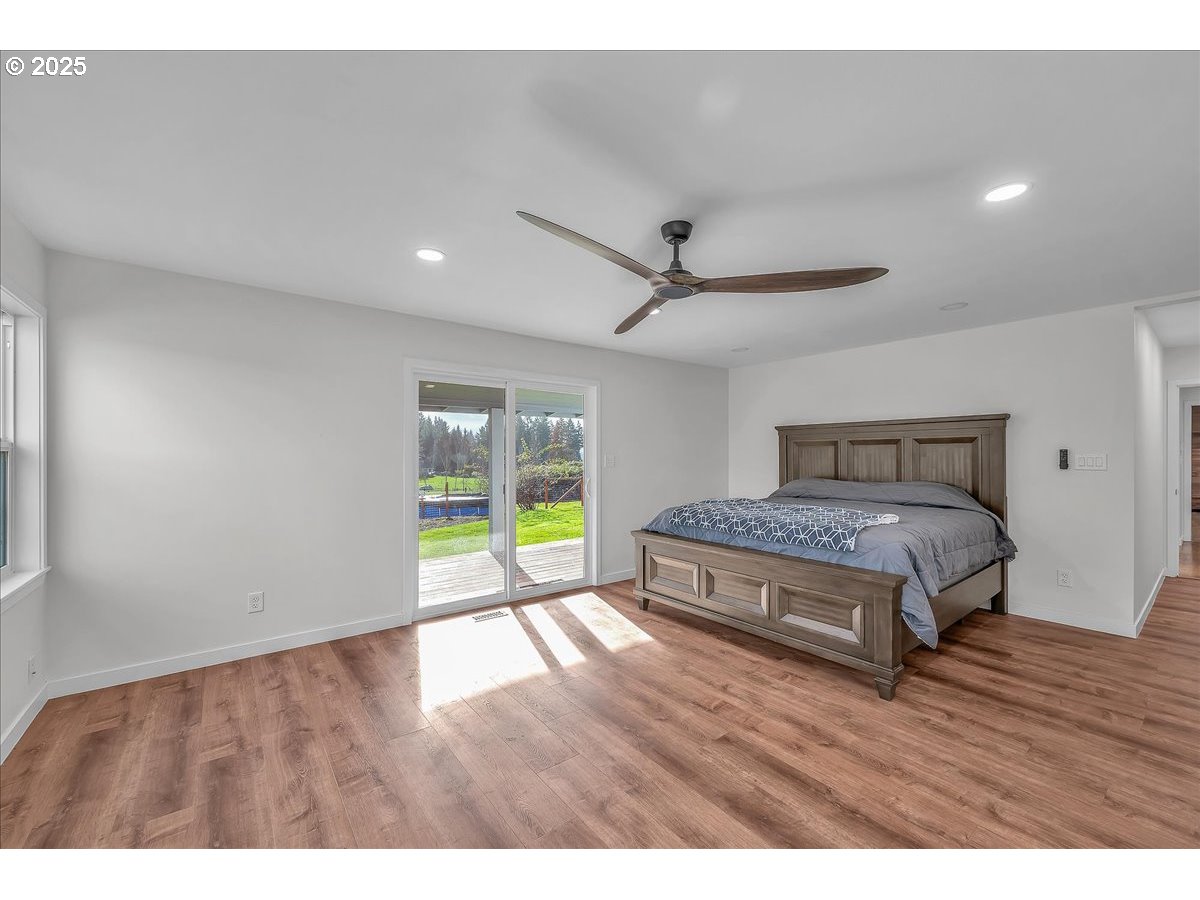 19448 Southwest Scholls Ferry Road Beaverton, OR 97007 - Photo 31 of 45 a spacious bedroom with a bed and a wooden floor