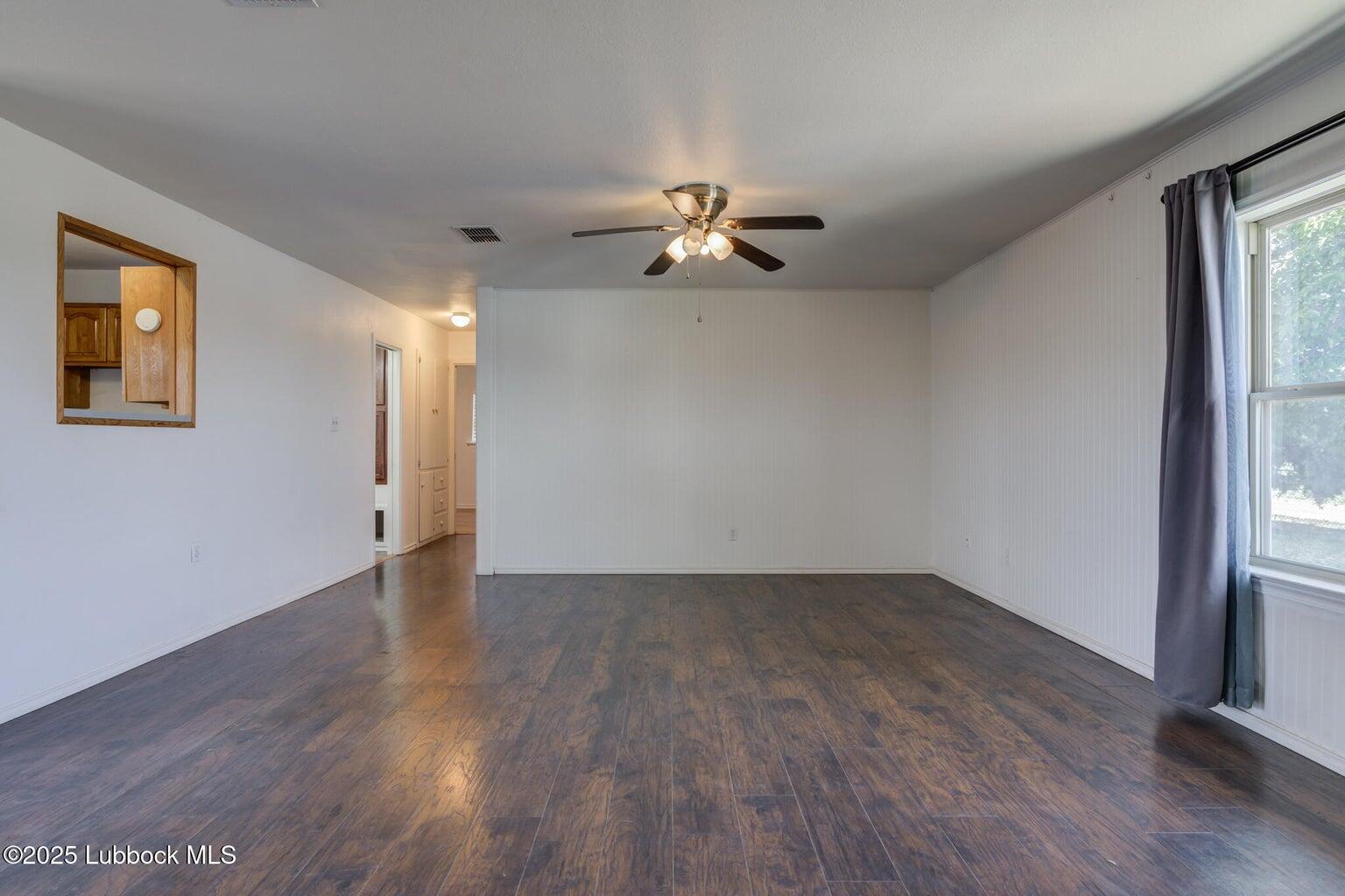 3506 Elm Avenue Lubbock, TX 79404 - Photo 4 of 12 a view of empty room with wooden floor and fan
