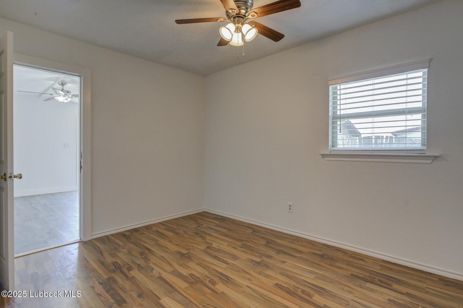 3506 Elm Avenue Lubbock, TX 79404 - Photo 9 of 12 an empty room with a window and wooden floor
