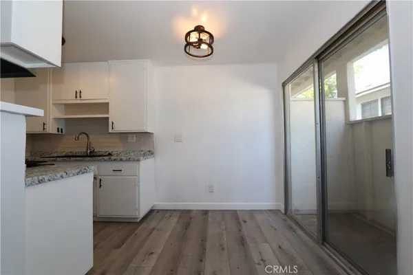 a kitchen with granite countertop a sink cabinets and wooden floor