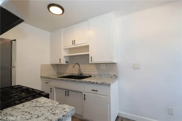 a kitchen with a sink stove and cabinets