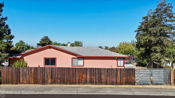 a view of a house with a small yard and wooden fence