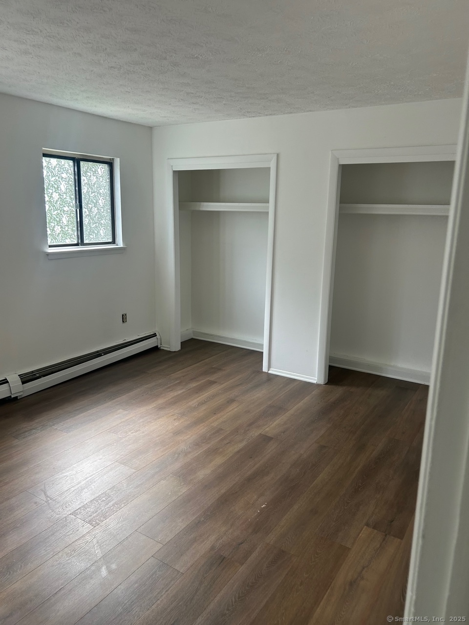126 Sutton Place, Unit 126 Bloomfield, CT 06002 - Photo 4 of 8 a view of an empty room with wooden floor and a window