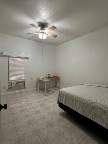 a spacious bedroom with a bed and a chandelier