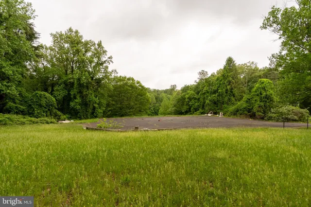 a view of a green field with wooden fence