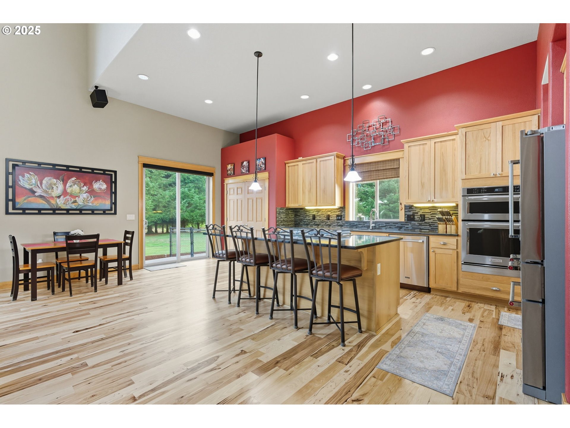 9573 South Gribble Road Canby, OR 97013 - Photo 17 of 48 a open kitchen with stainless steel appliances granite countertop a stove top oven a refrigerator a dining table and chairs with wooden floor