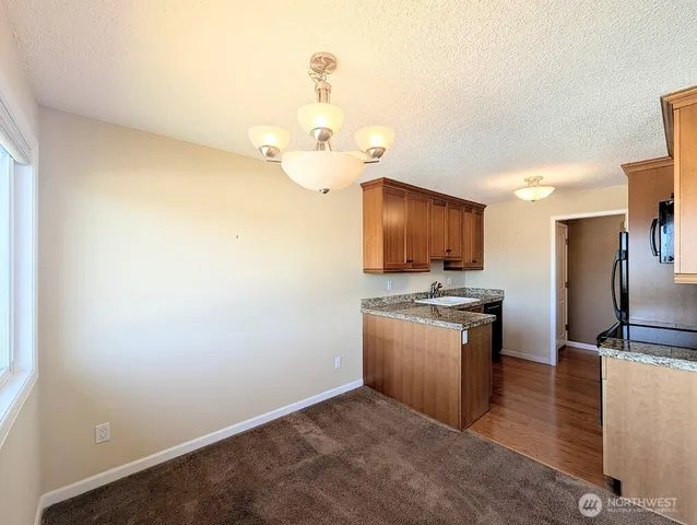 a kitchen with stainless steel appliances granite countertop a sink a stove and refrigerator