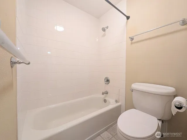 a white toilet and tub sitting next to a bathroom sink