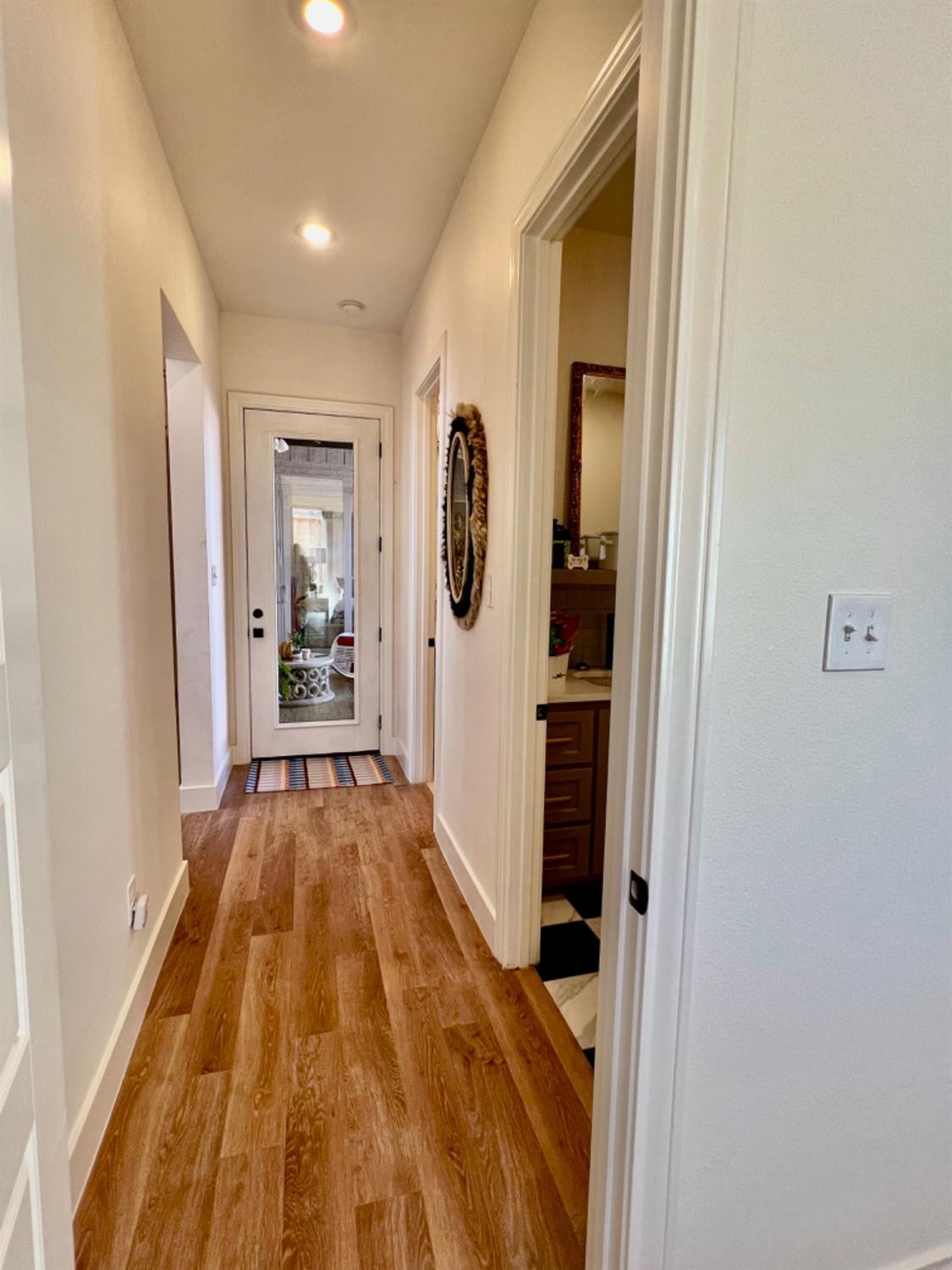 5902 112th Street Lubbock, TX 79424 - Photo 19 of 47 a view of a hallway with wooden floor and a bathroom
