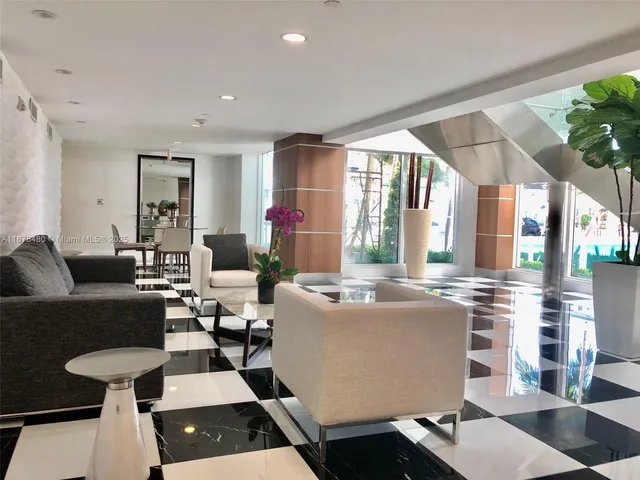 a room with a black white checkered floor with a gaming machine and a coffee table