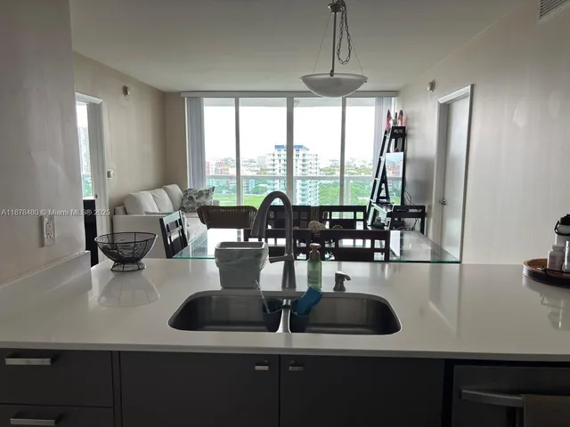 a kitchen with sink refrigerator and large window