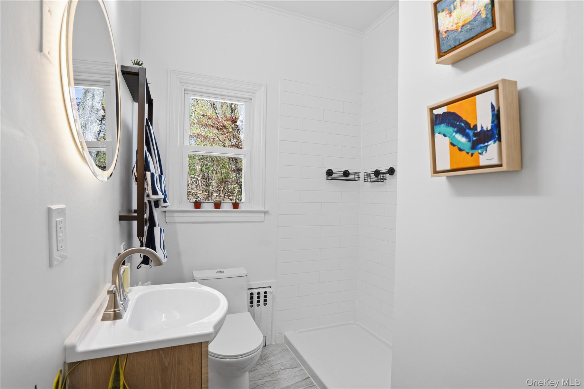 1550 Main Road Riverhead, NY 11901 - Photo 17 of 28 Modern bathroom featuring a wood-finish vanity with a white basin sink and brushed nickel faucet