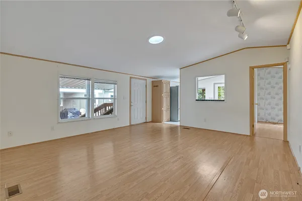 an empty room with wooden floor and windows