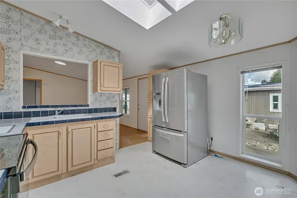 a kitchen with stainless steel appliances granite countertop a refrigerator and a stove top oven