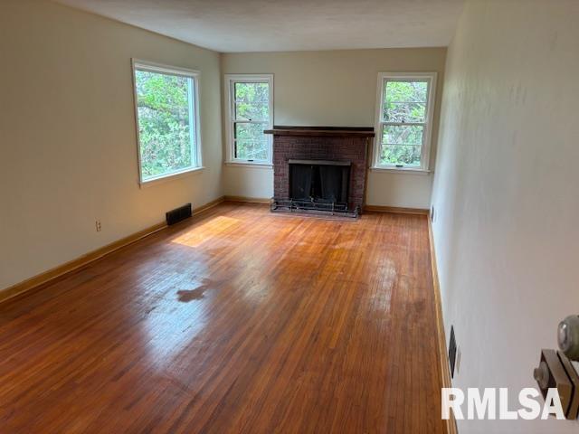 29470 Saxon Road Galva, IL 61434 - Photo 14 of 23 an empty room with wooden floor a fireplace and windows