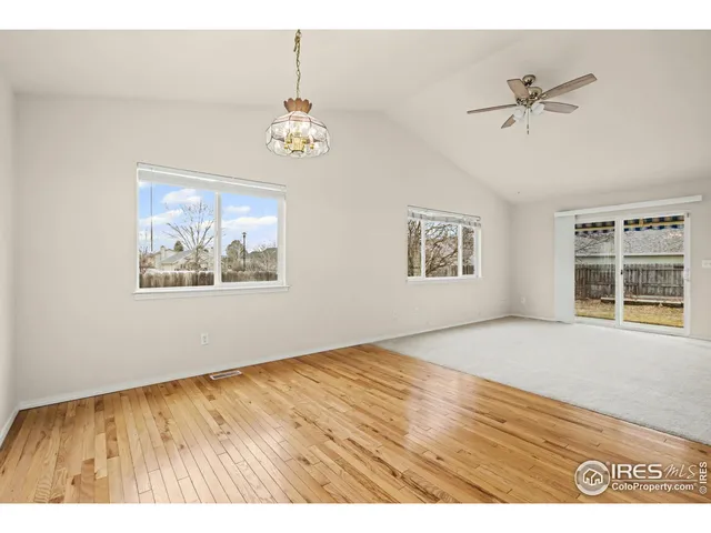 a view of an empty room with a window and a ceiling fan