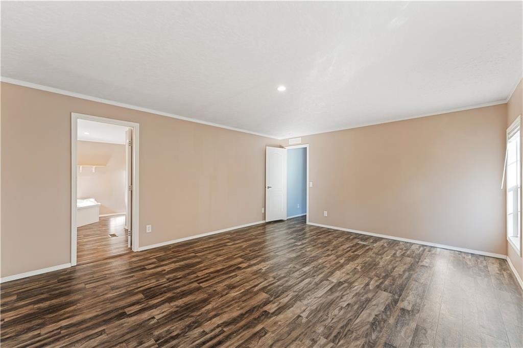 89 Ridge Road Seale, AL 36875 - Photo 21 of 46 Spacious room featuring wood-finish flooring, neutral-toned walls, a recessed ceiling light, and white trim
