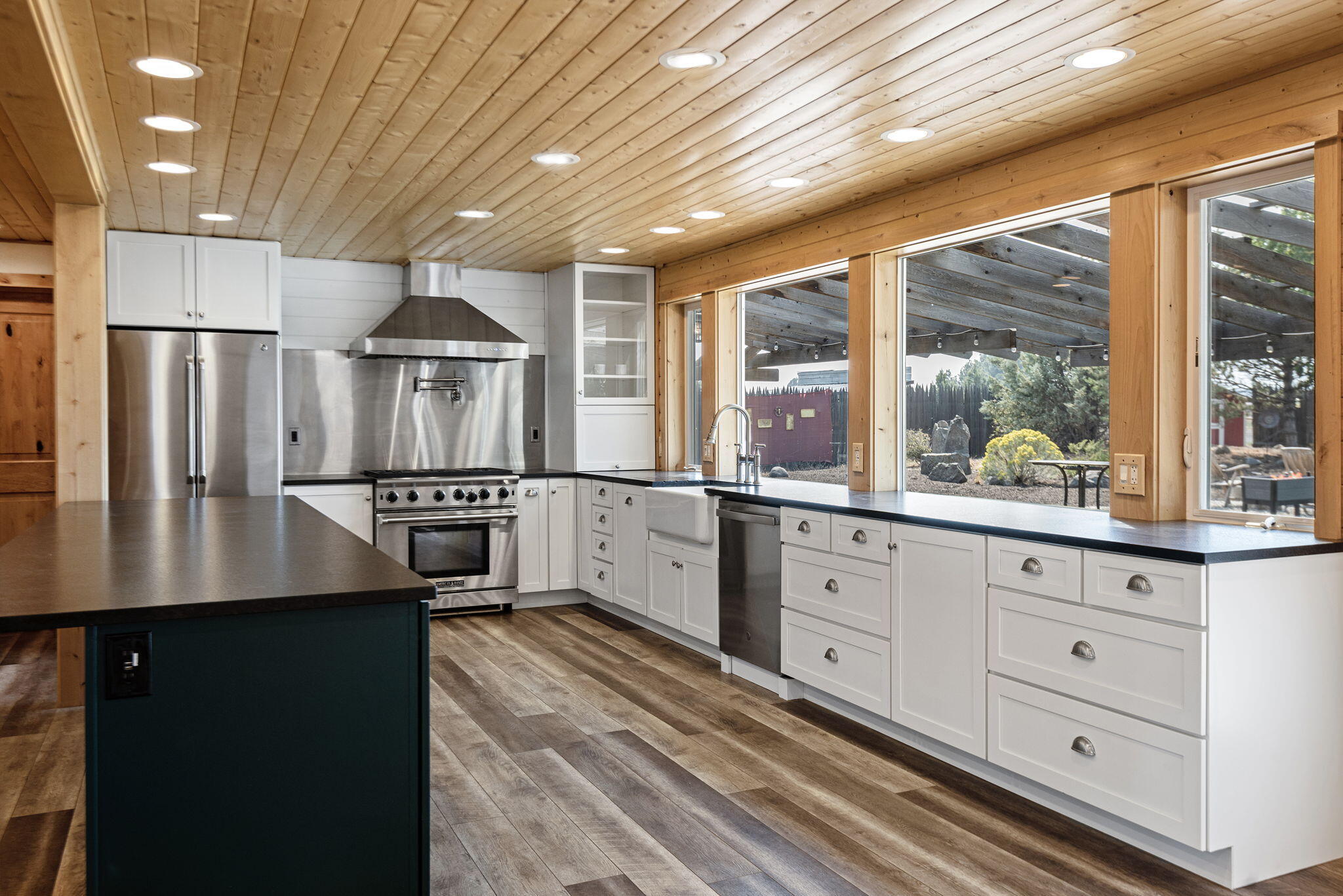 66901 Lance Road Bend, OR 97703 - Photo 20 of 71 a kitchen with granite countertop a refrigerator a sink and white cabinets