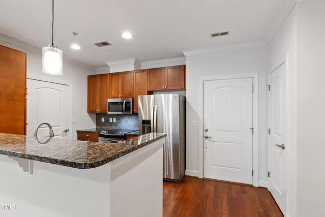 a kitchen with stainless steel appliances granite countertop a sink refrigerator and microwave