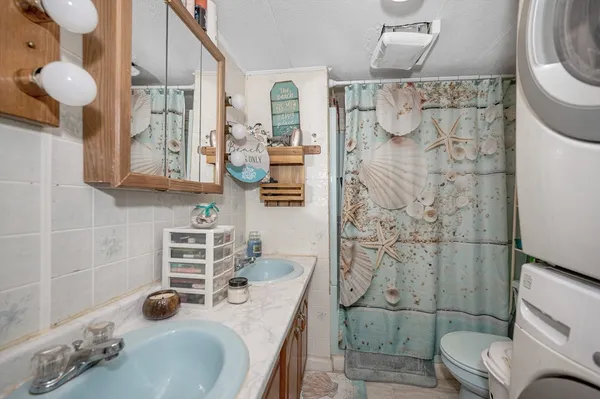 a bathroom with a granite countertop sink a toilet and shower