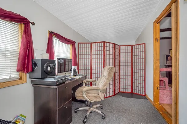 a view of a workspace with furniture and a window