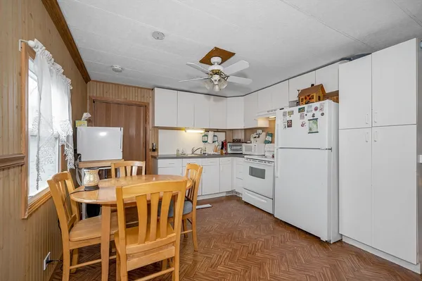 a kitchen with white cabinets and white appliances