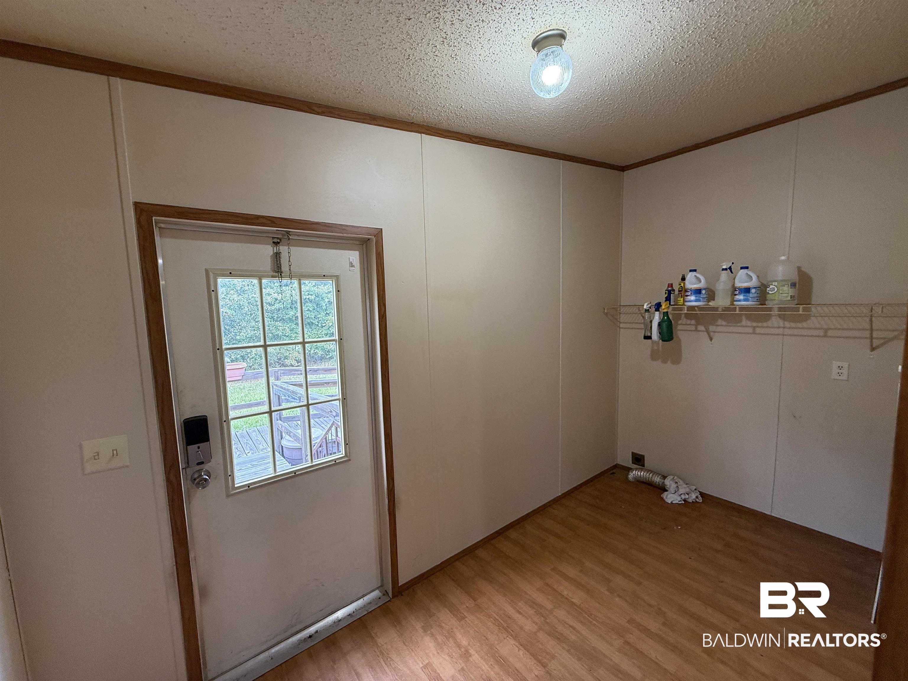 14402 County Road 55 Foley, AL 36535 - Photo 11 of 20 Laundry area featuring ornamental molding, a textured ceiling, and light hardwood / wood-style floors