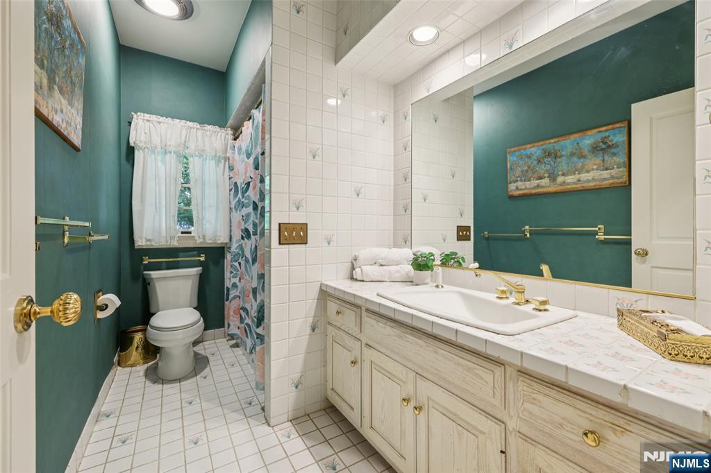 119 Sheridan Terrace Ridgewood, NJ 07450 - Photo 22 of 44 a bathroom with a granite countertop sink toilet and shower