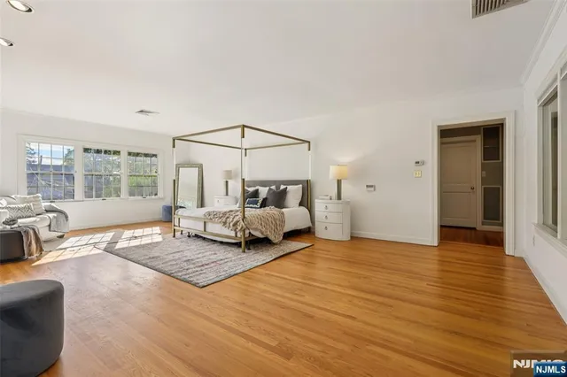 a spacious bedroom with a bed and glass door
