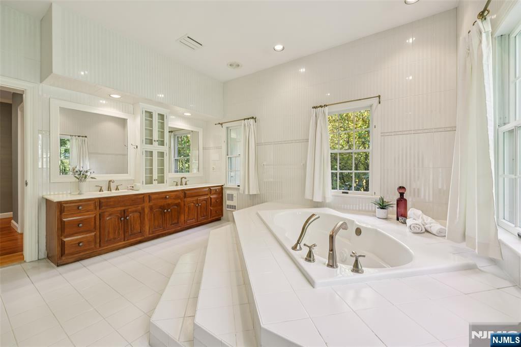 119 Sheridan Terrace Ridgewood, NJ 07450 - Photo 28 of 44 a spacious bathroom with a tub a sink double vanity windows and a sink