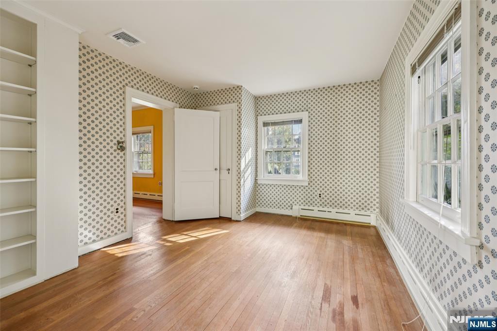 119 Sheridan Terrace Ridgewood, NJ 07450 - Photo 32 of 44 an empty room with wooden floor and windows