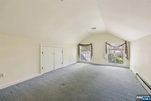 an empty room with windows and closet