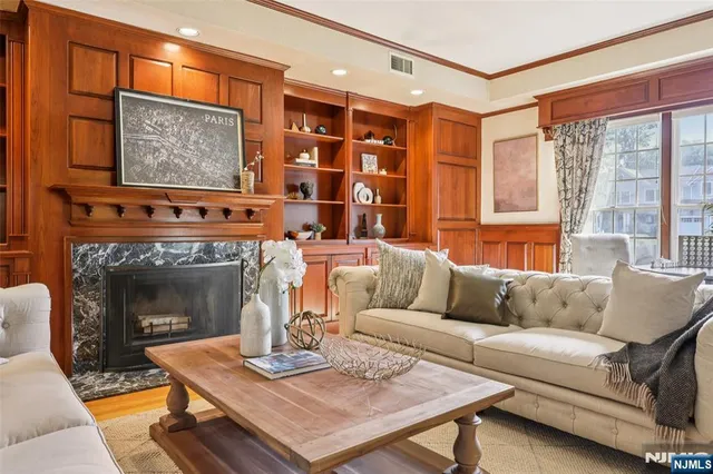 a living room with furniture a fireplace and a large window
