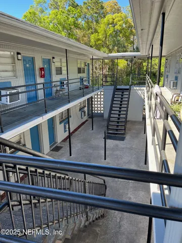 a view of a roof deck with wooden fence and a couple of chairs