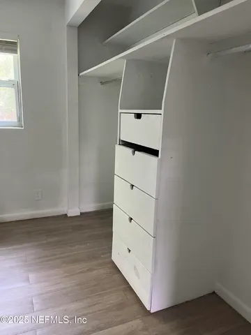 a view of walk in closet with empty racks