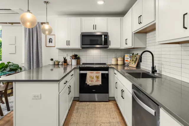 a kitchen with granite countertop a sink and a stove top oven