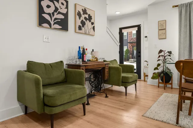 a living room with furniture and a dining table with wooden floor