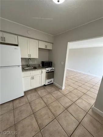 a kitchen with granite countertop a sink and a stove top oven