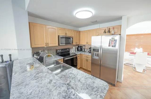 a kitchen with granite countertop a refrigerator and a sink